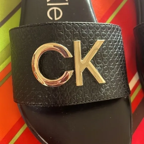 Brand New Calvin Klein Black Large Strap Sandals Flats w/ Gold Tone Metal Logo