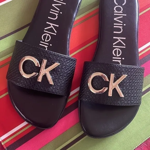 Brand New Calvin Klein Black Large Strap Sandals Flats w/ Gold Tone Metal Logo
